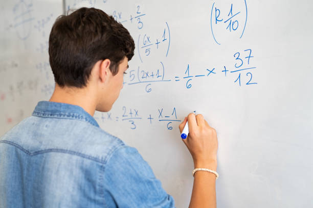 Student solving an algebra equation on a whiteboard
